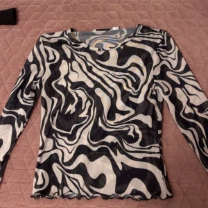 Svartvit meshtröja med abstrakt mönster - Säljer en långärmad meshtröja med svartvitt abstrakt mönster. Tröjan är tunn. Perfekt för att skapa en cool och trendig look, använt 1 gång endast! Storlek S