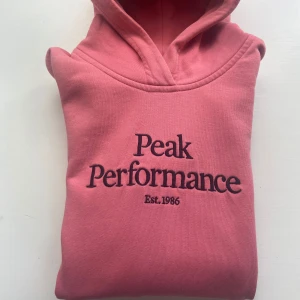 Peak Performance Hoodie  - Säljer nu denna Peak Performance hoodien i Corallrosa färg pga växt ur den. Storlek 160(se sista bilden) Den är använd fåtal ggr och är i mycket bra skick 10/10. Vid frågor eller funderingar tveka inte att höra av. 