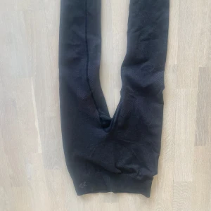 Svarta träningstights från lager 157 - Svart gråa träningstights  från lager 157 med ribbade muddar vid bensluten. Stretchiga, storlek xs/xxs ish