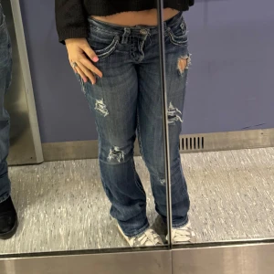 Blå low waist vintage bootcut jeans  - Säljer ett par low waist blå vintage bootcut jeans med håll och snygga detaljer på bakfickorna samt fram ❤️dom har spräckt i rumpan som på bild 3 men inget som syns/tänker på eftersom att dom har redan en lite sliten look och många detaljer , har sytt ihop själv och kunnat använda utan problem ❤️men annars som nya ❤️W25 L33 ~ stretchiga mer som en W26❤️köp via plick ❤️