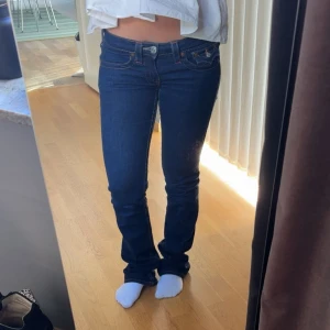 Mörkblå bootcut jeans från True Religion - Säljer ett par mörkblå jeans från True Religion. Dom har fickor där bak och är lågmidjade. Jätte snygga jeans!!!