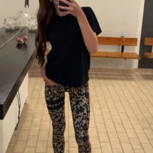 Leopardmönstrade tights från Stronger - Säljer ett par snygga leopardmönstrade tights. De har svarta detaljer med logga i midjan och på benet. Perfekta för träning och har en tight passform. Köpta för 899 kr