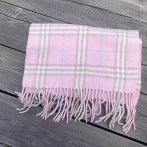 Rosa burberry halsduk - Säljer en fin rosa byrberry halsduk i okej skick, den är tvättad någon enstaka gång och är därför inte fullt så mjuk som den ska vara den finns fläckar, ett litet hål och några små revor