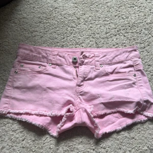 Rosa lågmidjade jeansshorts - Snygga jeansshorts med snygga slitningar i stolek xs, nästan aldrig använda då de är lite för små. Pris kan diskuteras!🥰