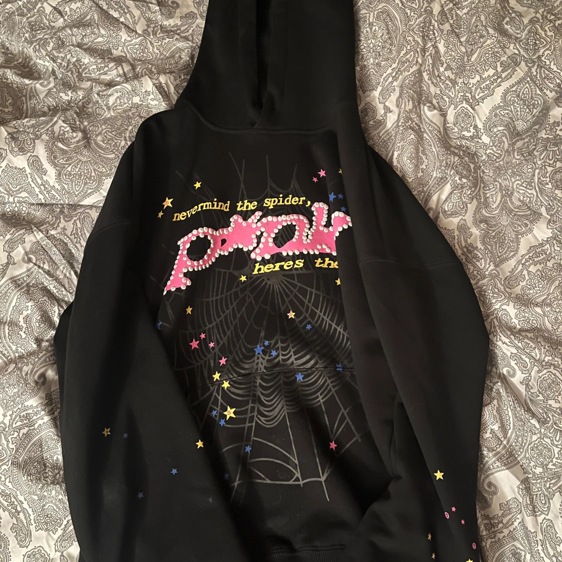 Svart hoodie från SP5DER med stjärnor och spindelnätsmönster