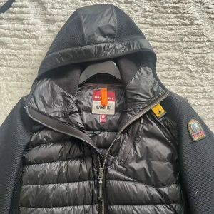 Svart hybridjacka med huva från Parajumpers - Säljer en svart hybridjacka från Parajumpers med quiltad framsida och huva. Köpt för 3200kr på Urban Modern! Nyskick!! Köpt i januari, kvitto finns.