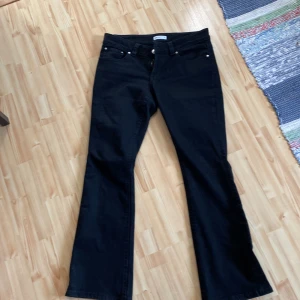 Svarta bootcut jeansbyxor - Svarta jeans med bootcut passform. Byxorna har knappar på bakfickorna. Helt nya använt en gång.  