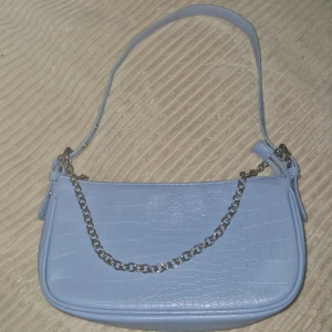 Väska - En blå väska med bra skik har andvänt 3 , 4 gånger mem passar inte min stil längre 