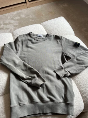 Stone island Junior - Stone island tröja i storlek 156cm.    Blandning mellan grön och gråt i färgen. Bra skick, ny pris 1600kr