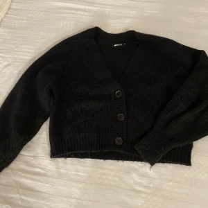 Svart kofta  - Svart stickad kofta från Gina tricot i storlek xs. Liten defekt på sista bilden 