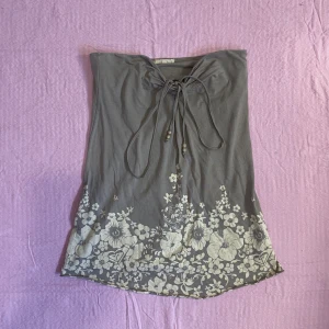 Topp - Vintage tube topp med fina detaljer🌺Den är grön/grå med beiga blommor och bruna träpärlor. Tror att man kan knyta den som en halterneck topp också!!🌞Möts gärna upp men kan även frakta (frakten kostar 66kr)🐚⭐️