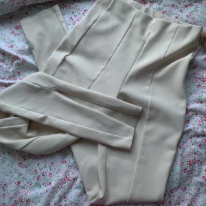 tajta beiga långa byxor med slits vid fötterna - är lite för långa för mig, jag tror dem är för att ha med klackar