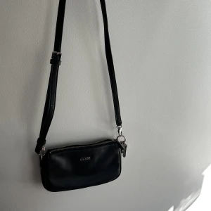 Guess väska - Jättefin axelremsväska från Guess som jag köpte förra året, justerbart band med bra utrymme👝köparen står för frakt 