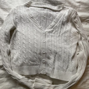 Vit kofta - En vit kofta som är lite v-ringad vid halsen och har fem knappar. Funkar perfekt att ha stängd som en tröja eller öppen som en kofta. Jätte fint mönster och den är som ny utan fläckar eller trasigt! Storleken är M men passar på mindre då den är rätt kort!