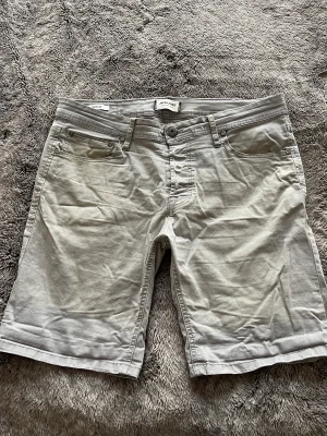 Grå jeansshorts från Jack&Jones - Grå jeansshorts från Jack&Jones med liten slitning på höger bakficka. Annars bra skick! Storlek M.
