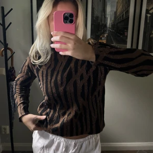 Tjocktröja med glitter - Snygg tjocktröja i svart och koppar-glittrigt mönster! Något högre i kragen. Märket heter Loul och är köpt på MQ. Storlek XS, mycket gott skick. 🤎