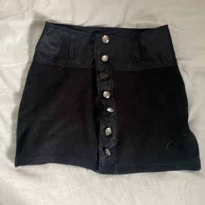 Kjol - Lagat en av knapparna, syns på andra bilden. Tajt kort 