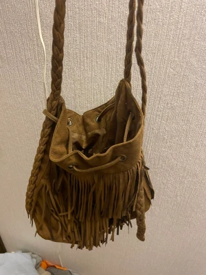 Axelväska  - En liten brun väska som inte kommer till användning längre. 