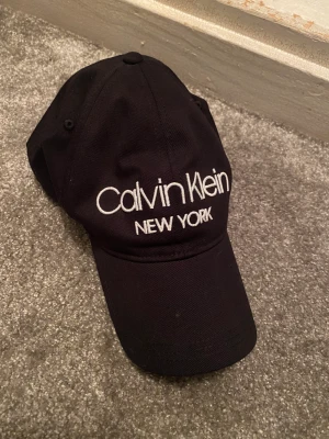 Calvin Klein keps  - Svart Calvin Klein keps med vit text, ställbar storlek bak 