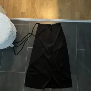 En lång svart satin kjol från bikbok i stolek Xs. Användt den 2-3 gånger.