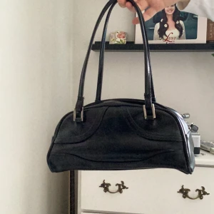 Svart axelväska  - Svart väska som rymmer jättemycket kunde ha en pocketbok, telefon, hörlurar. Köpt secondhand. Hör av dig om du vill ha fler bilder💕