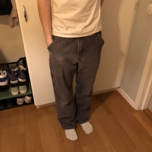 Gråa Carhartt Jeans  - Jättecoola Carhartt Jeans som inte används längre, köpta 2021 secondhand för 750kr. Byxorna är använda men i gott skick.  Mindre fläck finns på baksida (bild 2) Men syns ej och går säkert att tvätta bort!:) Pris går att diskutera , köpare står för frakt☺️