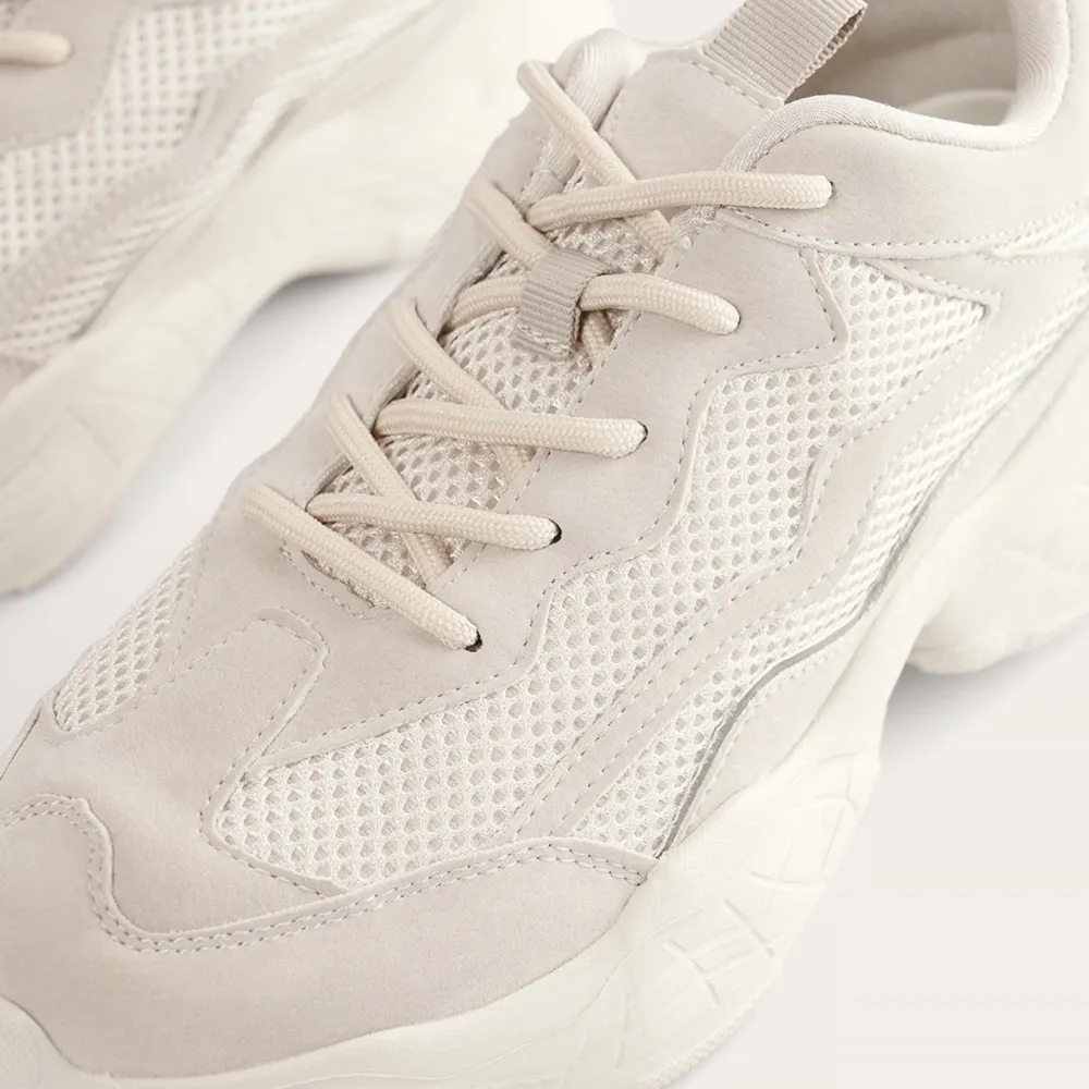 Sneakers köpta från NA-KD. Beige/gråa skor med litet reflexband på sidan. Använda fåtal gånger men ser helt nya ut, finns inga fläckar eller smuts på skorna. Storlek 37 🤎🤍🤎. Skor.
