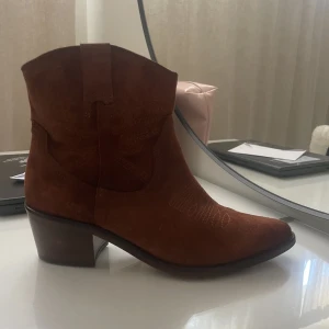 Cowboy skor - Helt oanvända låga cowboy skor i ljusbrunt. Dom är i storlek 40 men eftersom dom är spetsade där fram skulle jag säga att dom passar 38-39 bättre.