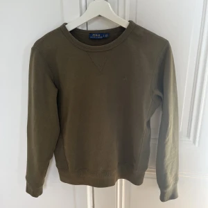 Ralph Lauren tröja  - Jättesnygg sweatshirt från Ralph Lauren i en olivgrön färg. Strl S. Den har en liten missfärgning längst ner (se sista bilden) verkligen inget som syns mycket!