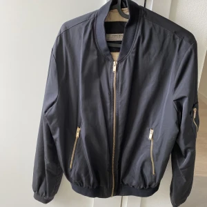 Bomberjacka svart - Svart bomberjacka med guldiga detaljer från Zara i storlek S.