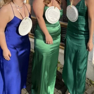 Grön balklänning - Den gröna balklänningen i mitten . silke som sitter jättefint på kroppen. Är 165 och den var bra i längden, några centimeter lång bara med 7cm klackar. Normal i ryggen med dragkedja som ej syns. Lite vattenfläckar men man ser inte det när den är på.