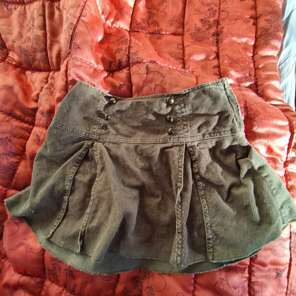 Militärgrön kort manchester kjol. Den är ganska liten i midjan men finns en dragkedja . Kjolar.