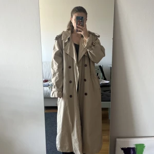 GANT trenchcoat - Måste tyvärr sälja min fina GANT trenchcoat då den är för stor på mig. Strl L. Jag på bilderna är 160 cm och den går nästan till golvet på mig. Lite skrynklig då den legat nerpackad ett tag men det går att fixa till enkelt! 