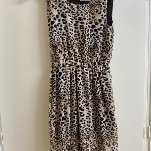 Leopard klänning  - En fin somrig leopard kläning. Luftig och skön. Bra material. För barn, ungefär 13 år. Brun, vit i svart färg