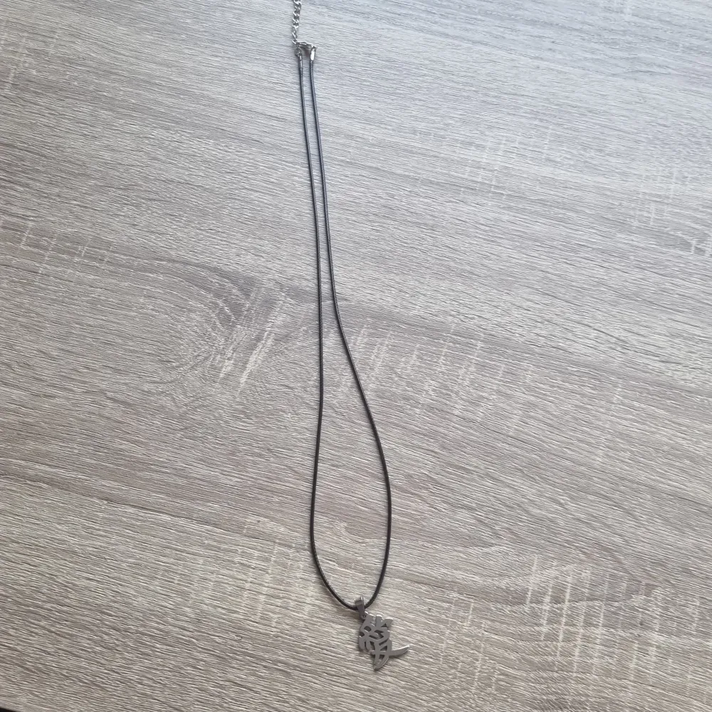 Silvrig halsband med japansk kanji. Kädian är 67cm lång.. Accessoarer.