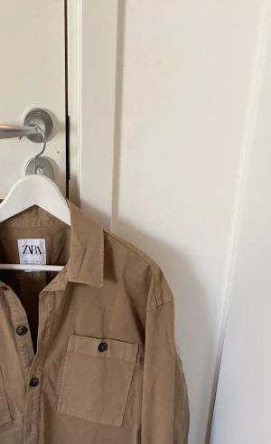 Zara overshirt storlek M - Säljer denna overshirt från Zara som legat nedpackad sedan köp. Storleken är M men ”relaxed fit” så passar även L. Säljer då jag inte gillar loose fit i overshirt. 