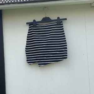 Kjol ej använd - En kort kjol med enkelt randigt mönster. Den är även oanvänd. 