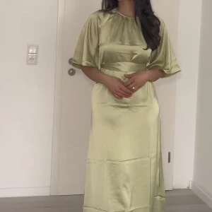 GRÖN SATINKLÄNNING - Säljer denna fina satinkläningen från HM. aldrig använd LÅNADE BILDER!! Nypris: 399kr
