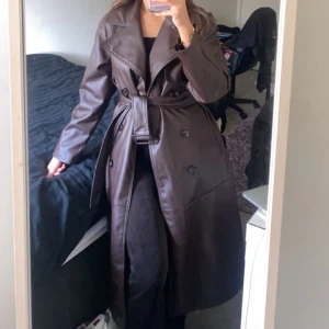 Skinn kappa  - En brun kappa av skinn. Kommer ner under knäna för mig som är 163cm. Den är i storlek S. Köptes för cirka 1k och det var få kvar. Finns inte längre att köpa på nätet. Säljer eftersom att jag har svårt att matcha. Använd endast 2-3 gånger och är i nyskick.