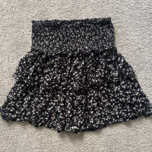 Kjol - Jättesöt volangkjol med små blommor från kapphal. Storlek XS men det är stretchigt material så den passar även S. Använt kanske 2 ggr så den är i nyskick. 