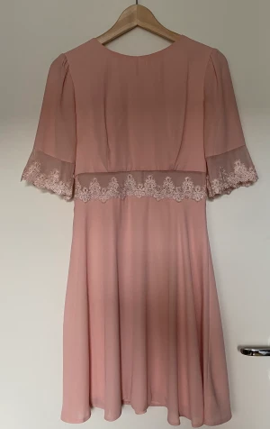 Klänning - Ljusrosa klänning med meshdetaljer på ärmarna och midjan