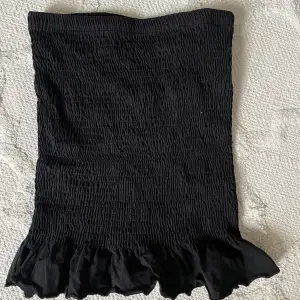 Smockad svart kjol med en liten volang. Från Gina tricot. Stl XS. Skriv för fler frågor eller intresse 