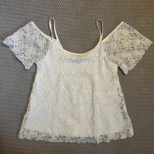 Topp - Vit topp med tunna axelband och offshoulder.