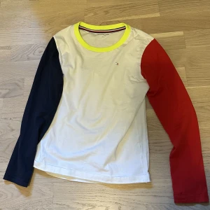Tommy Hilfiger tröja - Tommy Hilfiger topp i helt nytt skick, storlek 152. Köpt från Kids Brand store. Fina färger och en väldigt unik modell som sitter riktigt skönt och passar till allt. 