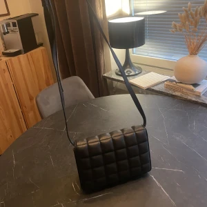 Svart väska  - Svart väska med axelband. Såå fin men används alldeles för lite så säljer.