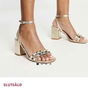 Guldiga klackar från asos, slutsålda!! - Ett par guldiga klackar från asos, lite Valentino inspirerade med nitar! Helt slut på asos! Använda enbart ett tillfälle så i fint skick!! Nypris 430kr! I storlek 37 som passar mig med 38!