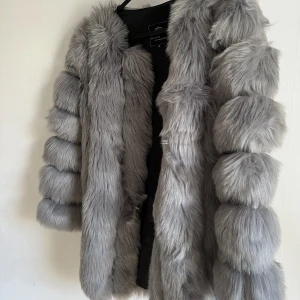 Pälsjacka  - Grå pälsjacka, inte äkta päls. Helt ny, endast använd ett fåtal gånger. 