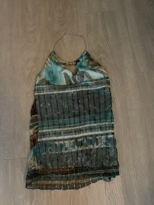 Fest topp - Cool halterneck festtopp!! Som ni kan se på sista bilden är den lite genomskinlig på baksidan. Köpt begagnat från Sellpy men endast använd 1 gång samt inga defekter💓💓