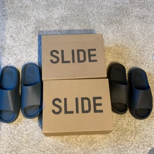 Yeezy slides - Säljer ett av dessa par slides. Båda har jag vunnit på raffle från adidas hemsida. Silver är oanvända och svarta är lite använda. Skriv vid intresse så kan vi komma överens om pris