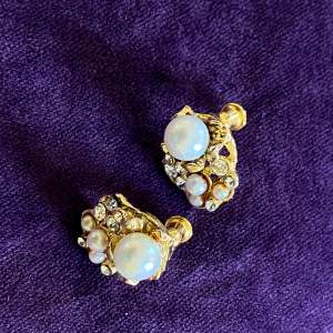 Små guldfärgade örhängen med pärlor  Okänt material 